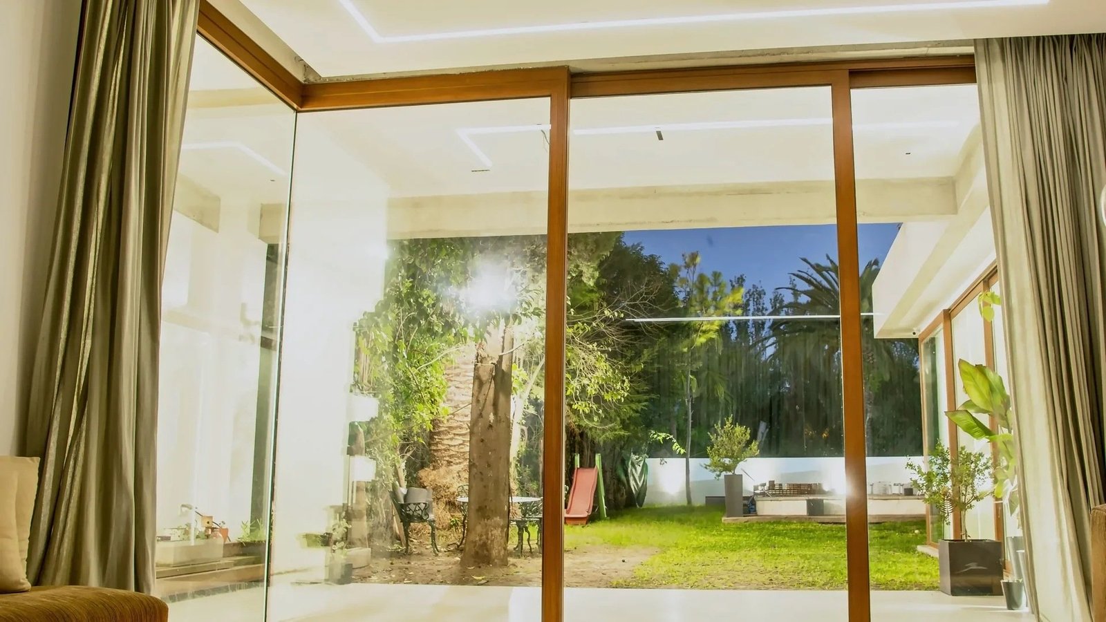Residencia. Paño corredizo en esquina con marcos símil madera.